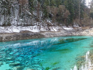 清澈蓝绿湖水与岸边雪景