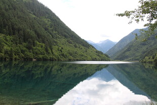 青山环绕的静谧碧绿湖泊