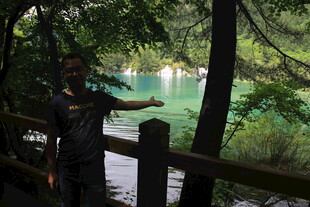 男子于林间赏碧绿湖水