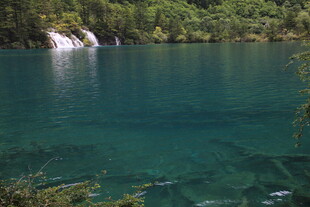 翠绿山林间的澄澈蓝湖