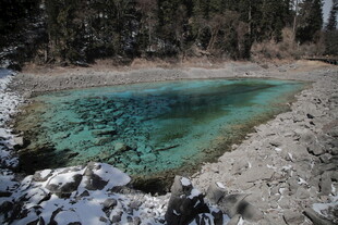 雪覆湖畔的澄澈蓝绿色水域