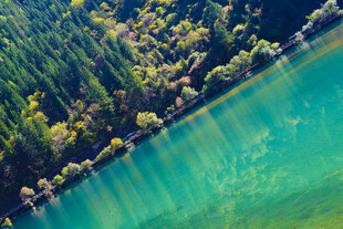 翠绿山林环绕的碧色湖水