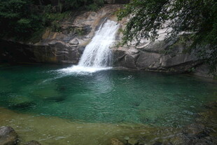 山间清澈瀑布下的碧绿潭水