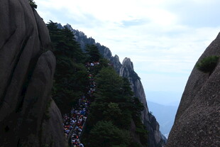 黄山陡峭山路上的游客