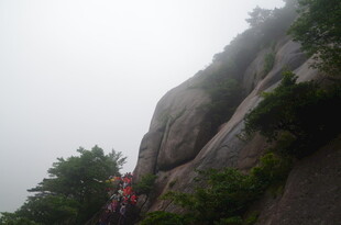 雾中攀岩者勇攀陡峭岩壁