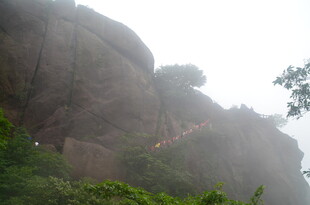 云雾中攀登陡峭山壁