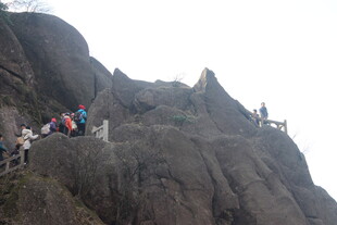 游客攀登陡峭山峰