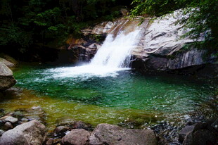 山间清澈瀑布下的碧绿潭水