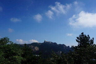 蓝天绿树间的远山景致