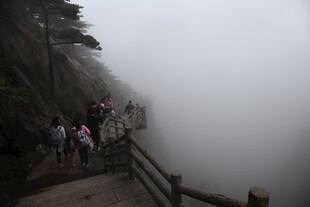 雾中栈道上的游客身影