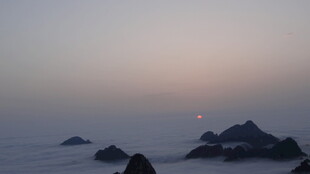 日出云海中的嶙峋山峦