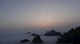 海上日出时分的云雾礁石