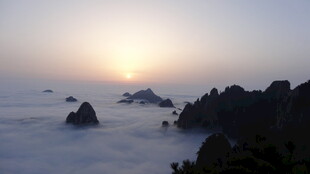 海上日出云雾中的礁石