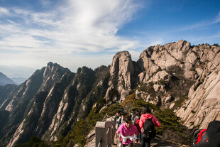 游客攀登壮丽山峰景观