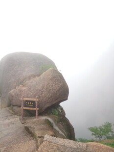 雾中巨石旁的观景小亭