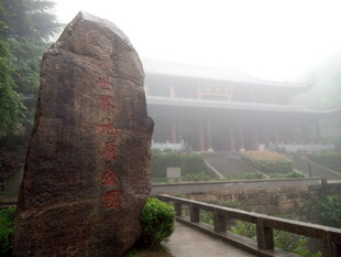 雾中巨石旁的中式建筑