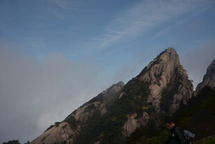 巍峨山峰耸立于蓝天白云间