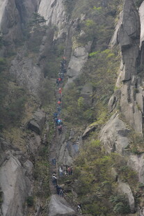 山间陡峭崖壁上的徒步者