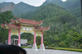 中式牌坊立于青山绿树间