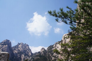 峻岭蓝天间的悠然白云