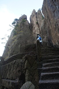 攀登陡峭山间石阶的旅人