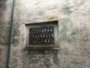 老旧墙面带铁栏的小窗