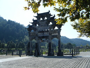 古朴牌坊立于山水间