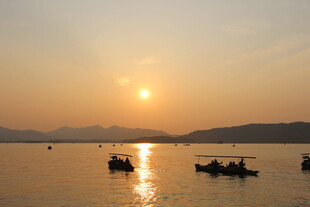 夕阳下的湖面泛舟景象