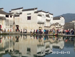 水乡古建旁的人群倒影风光