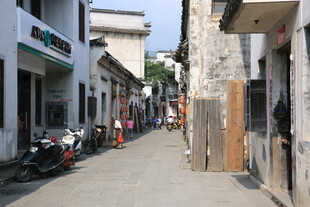 狭窄街道旁的店铺与车辆