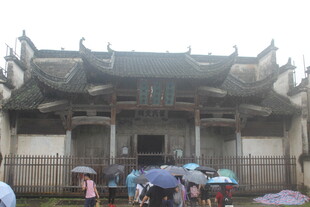 古建前撑伞驻足的人群