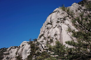 巍峨山石与蓝天绿树