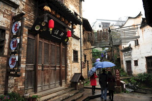古巷雨中景 行人撑伞行