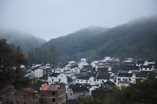 山间雾绕的白墙黑瓦村落