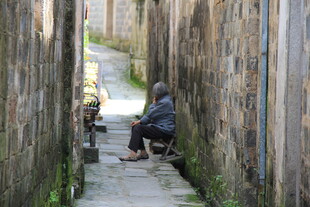 狭窄小巷中独坐的身影