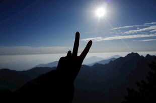 山顶剪影 阳光下的胜利手势