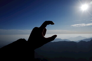 手托太阳于山峦云海间