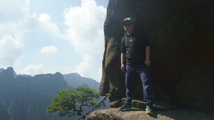 男子立于山巅岩石处