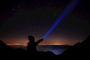 夜空中持激光的人物剪影