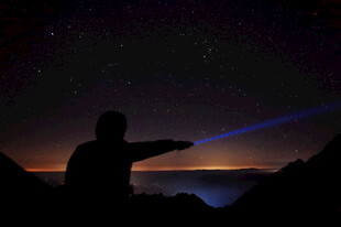 夜空中的人影与蓝色光束