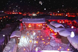 雪夜中的灯火通明古村落