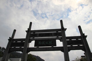 中式牌坊立于蓝天白云下