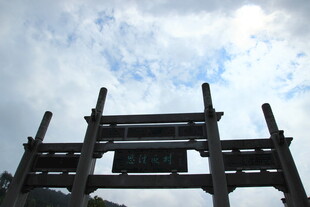 古朴牌坊立于蓝天白云下