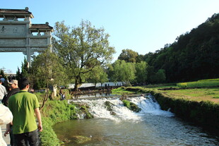 溪边游人赏景的惬意画面