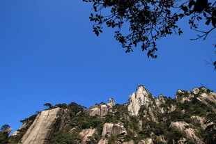 峻峭山峰与蓝天绿树