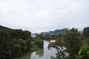河畔葱郁山林风景图