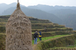 山间稻草垛旁的徒步者