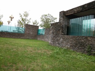 石墙玻璃建筑旁的绿草地