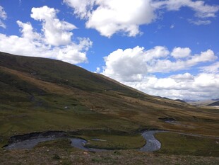 草原溪流与蓝天白云美景