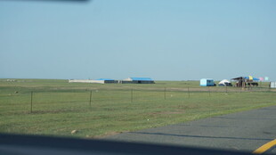 公路旁开阔草地与远处建筑